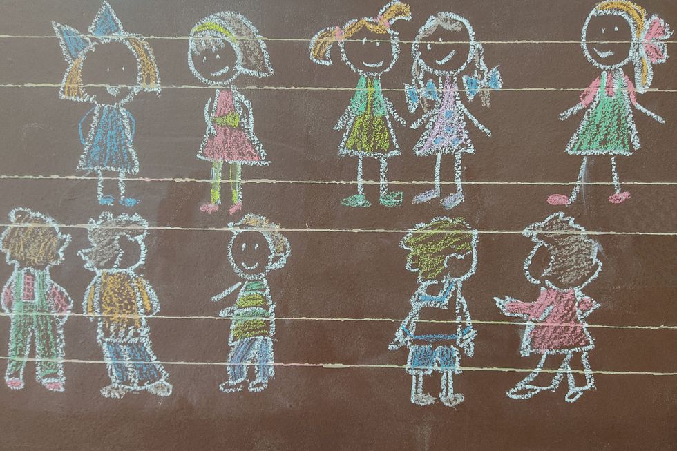 Kreidezeichnung von Kindern auf Wandtafel