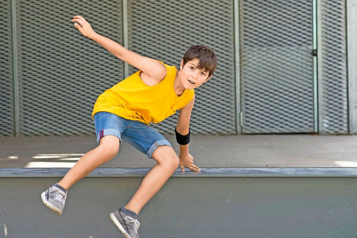 1149603345 Ein Junge springt über eine Hürde.