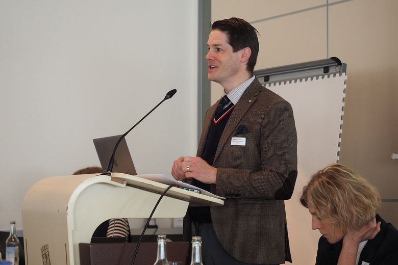 Beat Schwendimann steht an einem Rednerpult und spricht. 