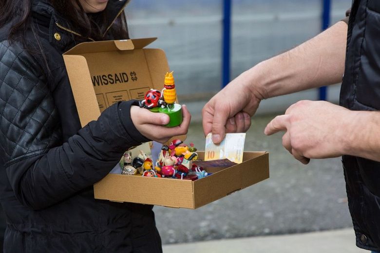 Eine Schülerin verkauft für Swissaid kleine Holzfiguren. Foto: Swissaid