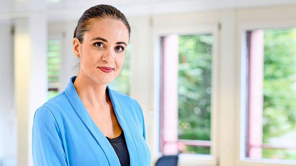 Dunkelhaarige Frau mit blauer Jacke.