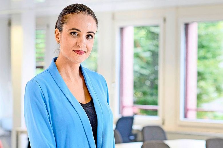 Dunkelhaarige Frau mit blauer Jacke.