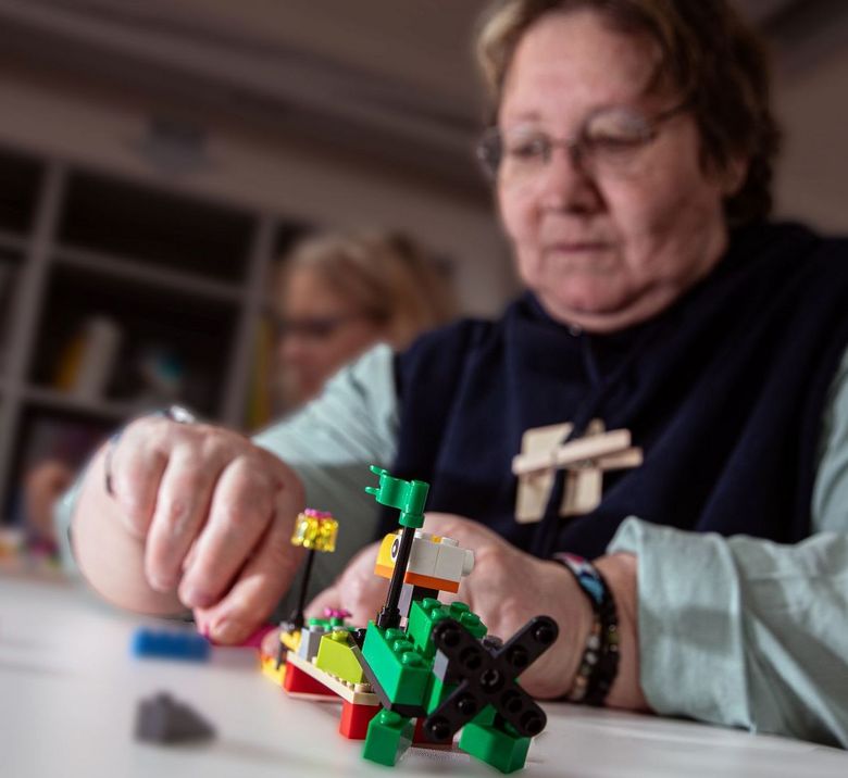 Eine Frau setzt Legos zusammen.