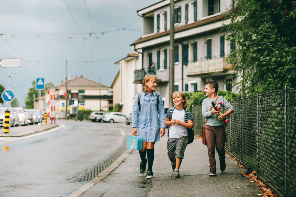 Drei Kinder unterwegs auf dem Trottoir