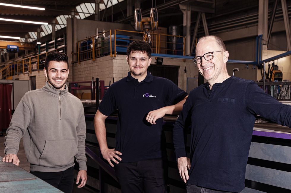 Das Team der Metallbaufirma steht in einer grossen Halle.
