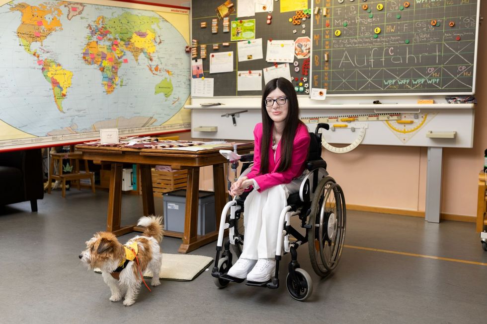 Frau im Klassenzimmer mit Hund.