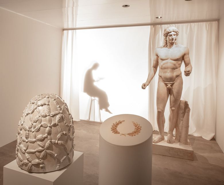 Eine Schattenfigur im Hintergrund mimt das Orakel von Delphi.