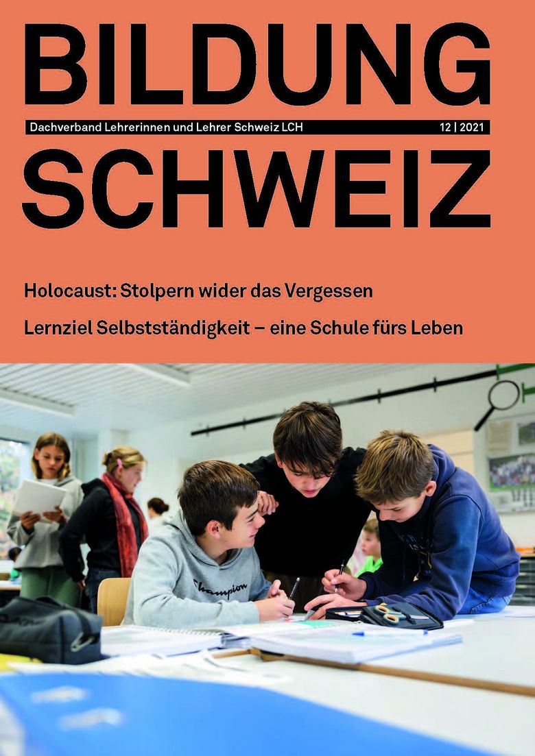 Cover der Dezemberausgabe 2021 von BILDUNG SCHWEIZ zeigt drei Schüler, wie sie sich im Klassenzimmer besprechen.