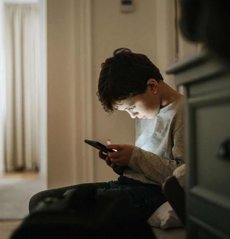 Ein Kind schaut gebannt in sein Handy.