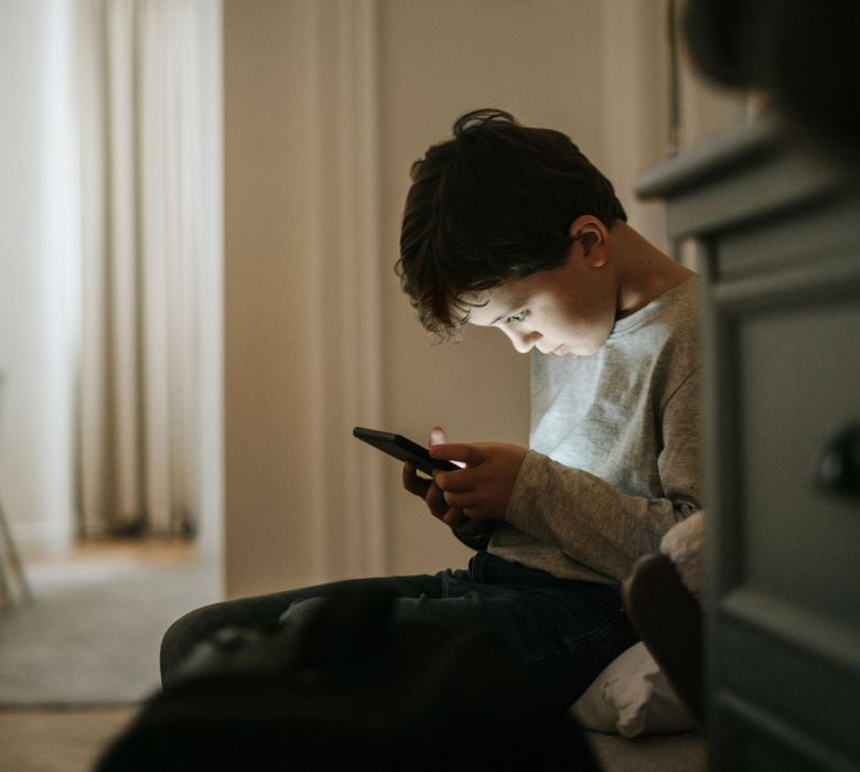 Ein Kind schaut gebannt in sein Handy.