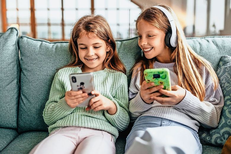 Zwei Mädchen tippen auf ihren Smartphones.