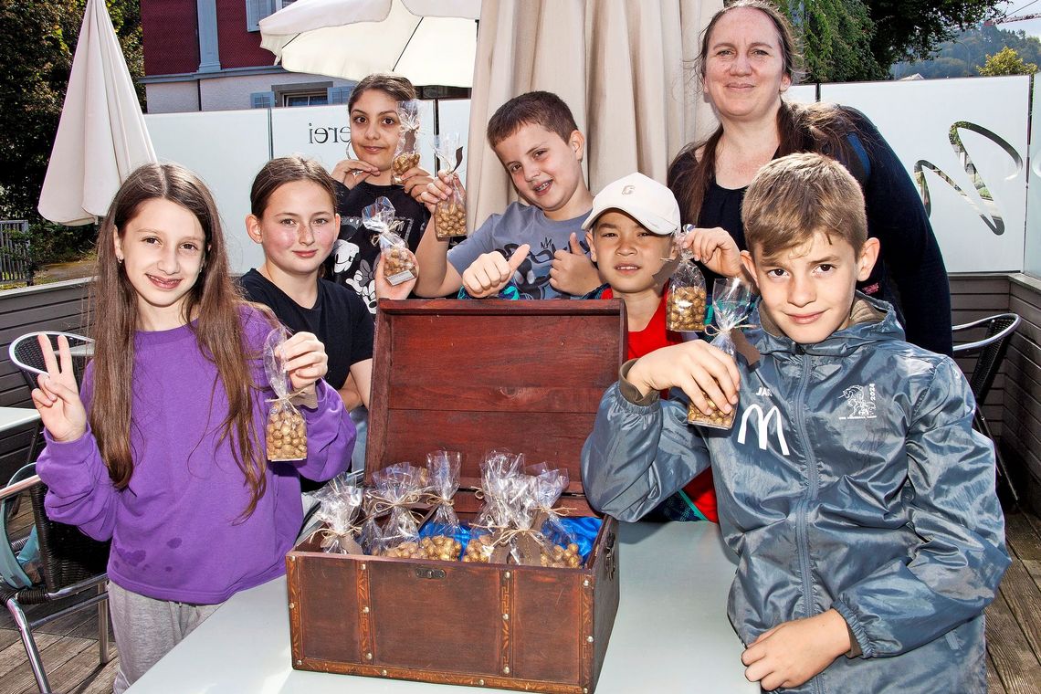 In einer Schatztruhe finden Kinder goldene Schokoladekugeln.