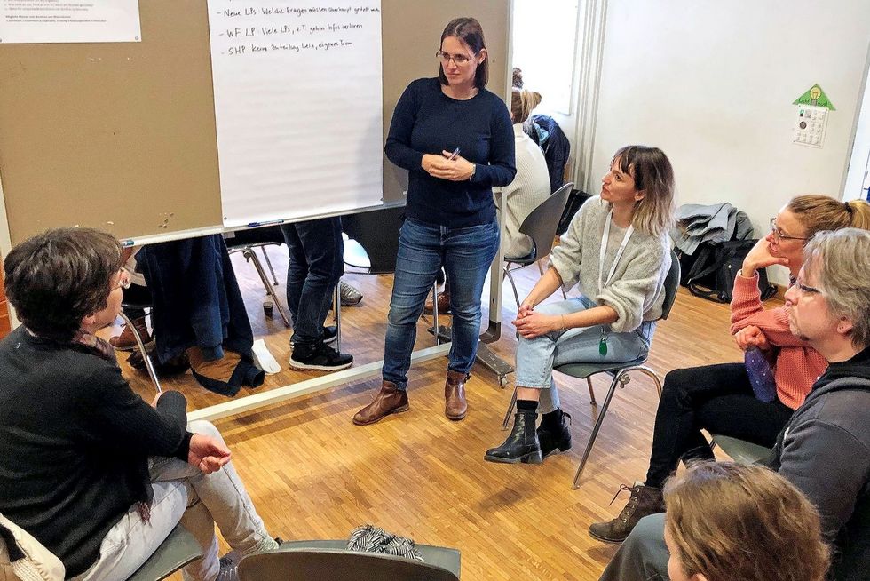 Eine Arbeitsgruppe sitzt vor dem Whiteboard.