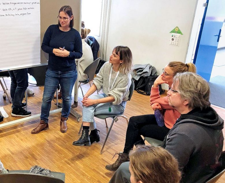 Eine Arbeitsgruppe sitzt vor dem Whiteboard.