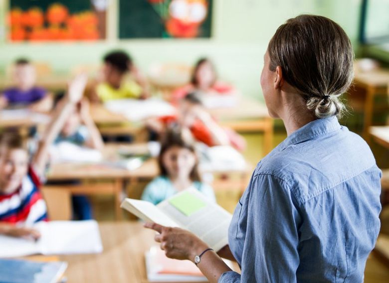 Eine Lehrerin steht vor ihrer Klasse.
