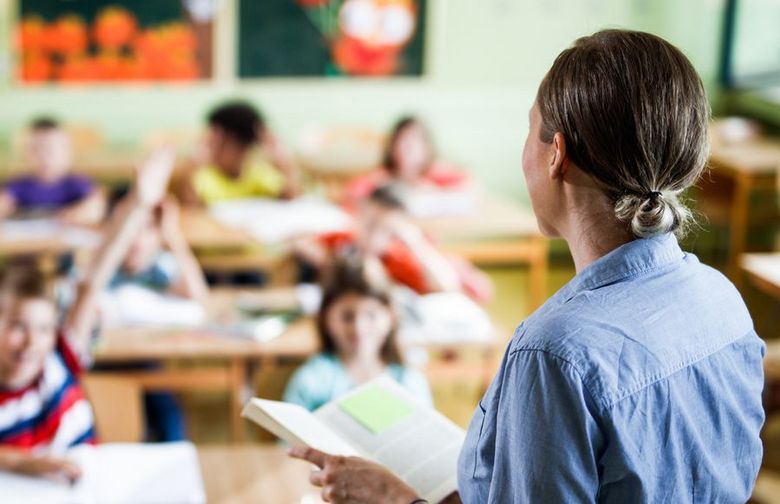 Eine Lehrerin steht vor ihrer Klasse.
