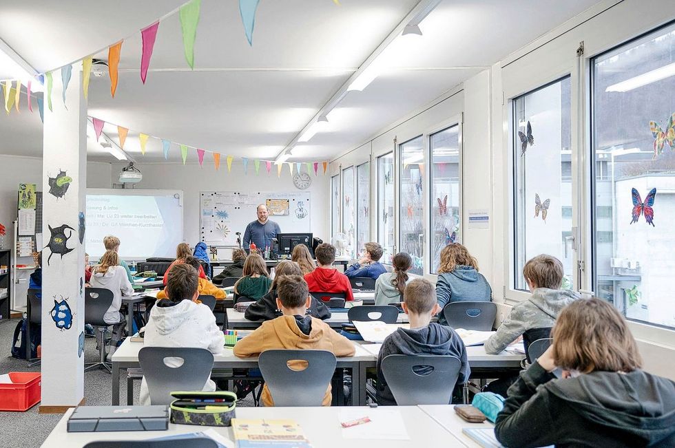 Ein Lehrer unterrichtet seine Klasse in einem umgebauten Büro.