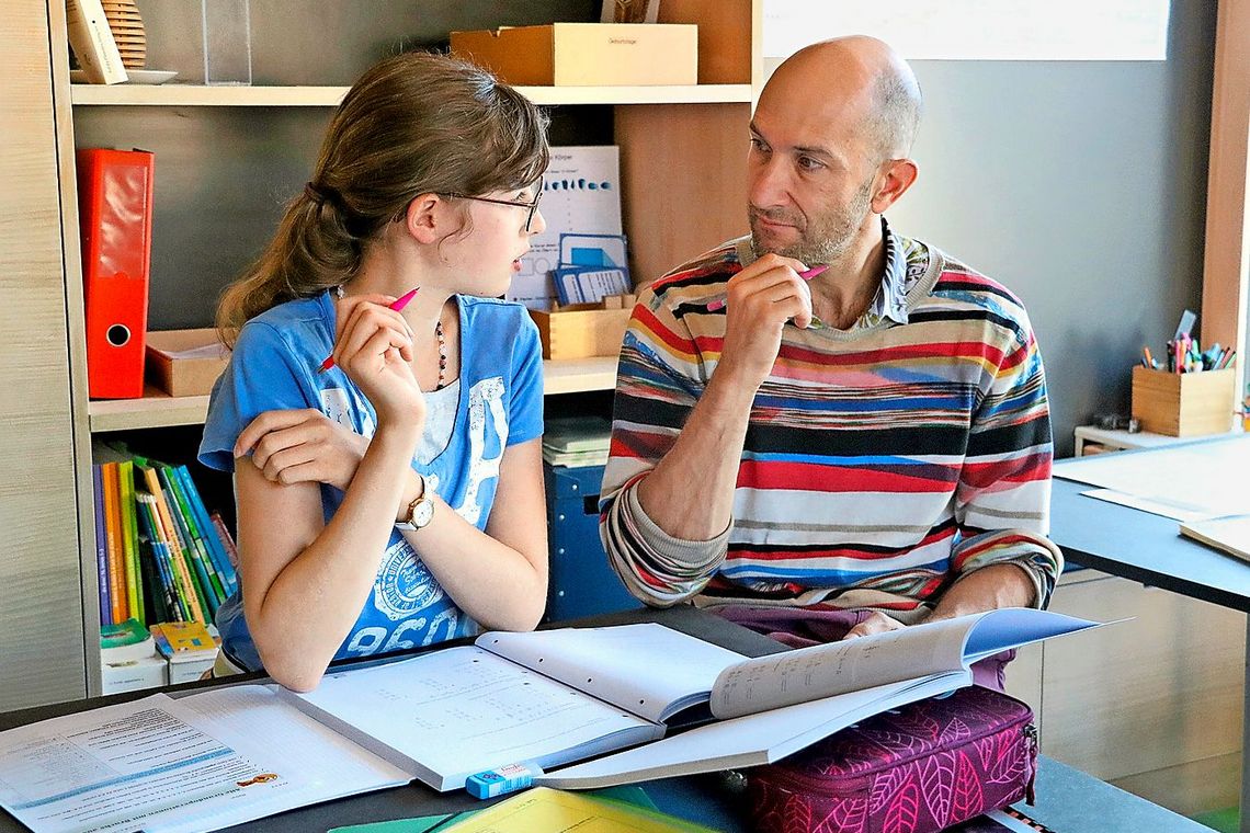 Eine Schülerin im Gespräch mit einem Lehrer.