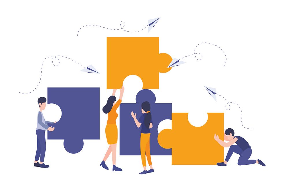 Vier Menschen mit je einem Puzzleteil setzen ein Bild zusammen. 