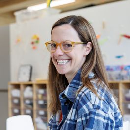 Eine Frau mit Brille lächelt in die Kamera.