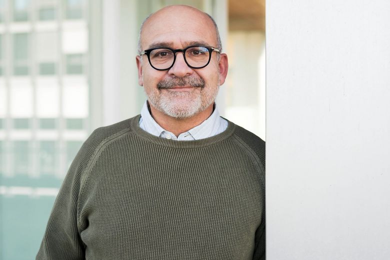 Ein Porträtfoto von Marc Halter. Darauf trägt er eine Brille und er lehnt gegen eine Wand.