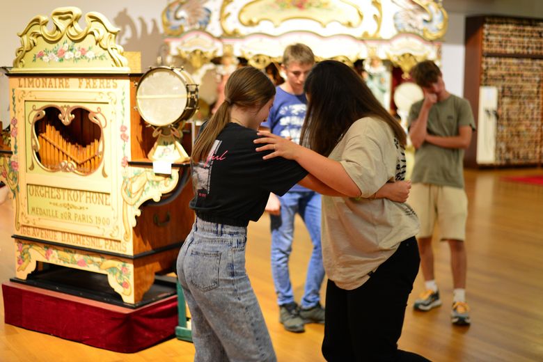 Zwei Mädchen tanzen zur Musik eines alten Automaten.