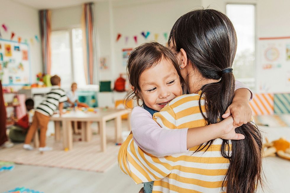 Kleines Kind umarmt eine Frau.