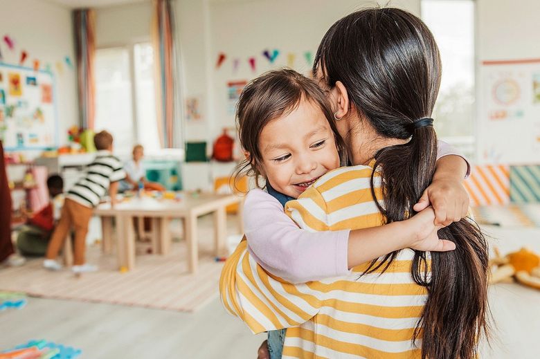 Kleines Kind umarmt eine Frau.