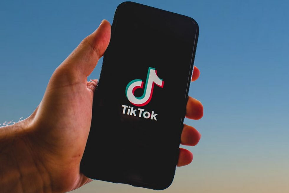 Eine Hand hält ein Smartphone. Auf dem Gerät ist das Tiktoklogo abgebildet.