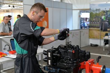 Ein junger Mann mit Schutzbrille arbeitet an einer Maschine.