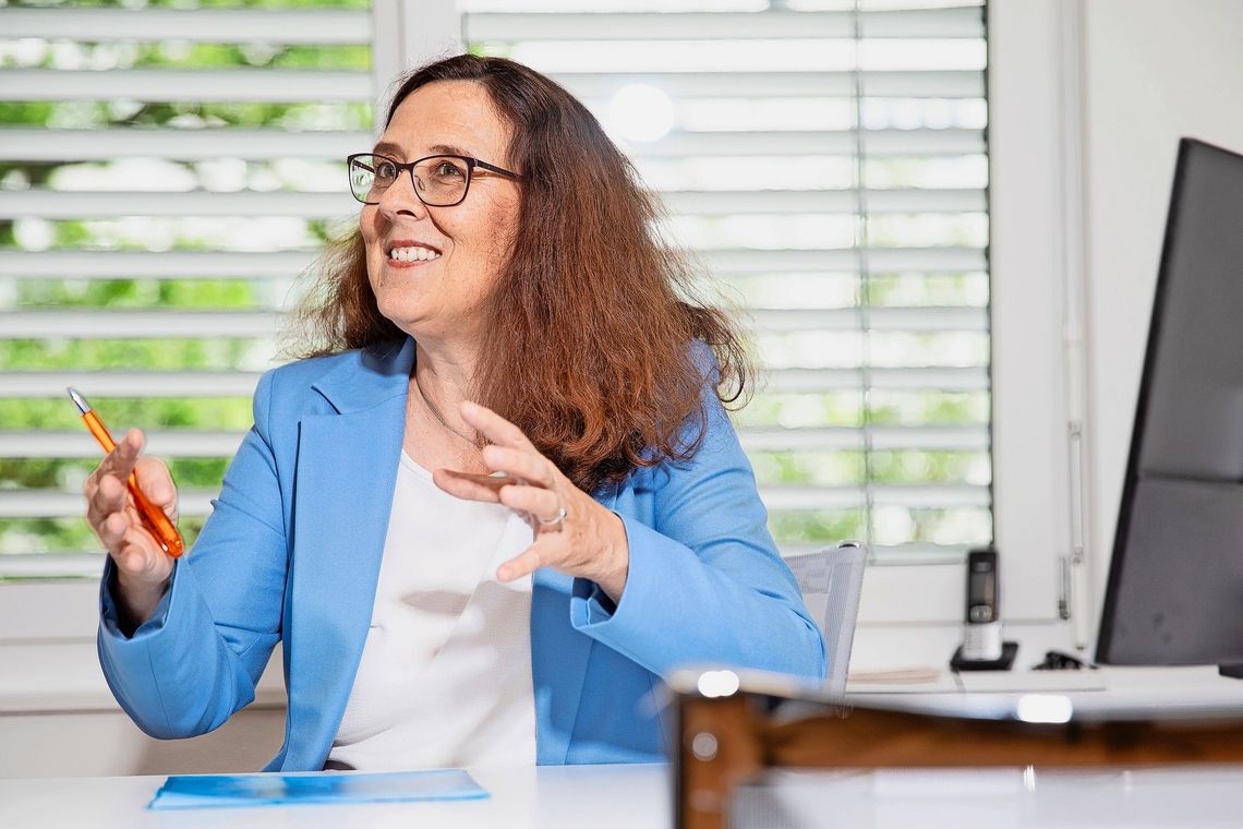 Franziska Staub sitzt am Tisch und gestikuliert während sie spricht.