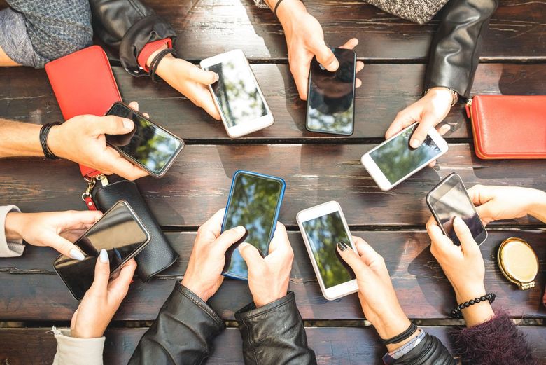 Blick auf einen Tisch voller Smartphones.