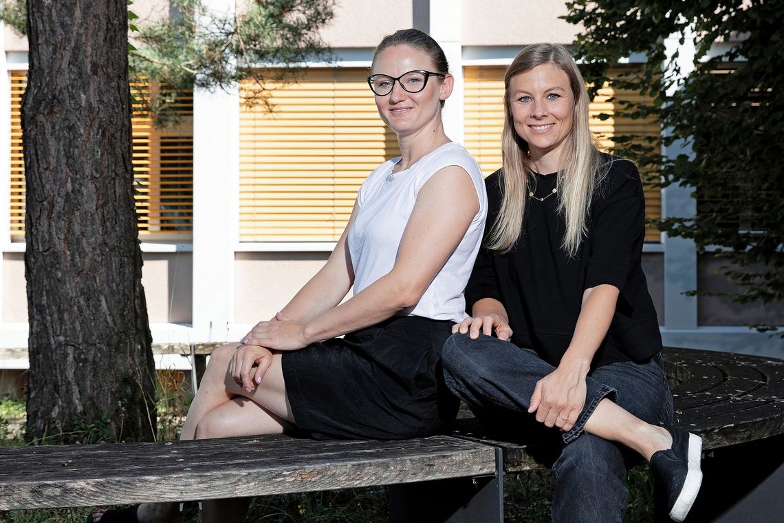 Im Pausenhof sitzen Carmen D’Alpaos und Patricia Locher auf einer Mauer.