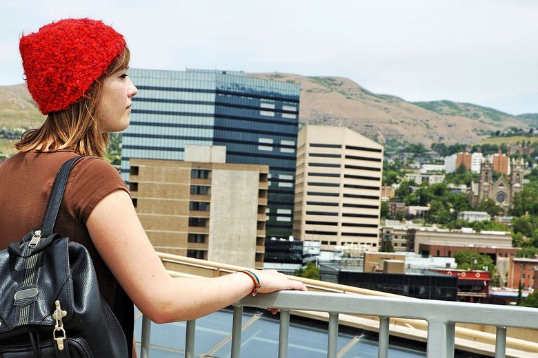 184093162 Jugendliche steht am Geländer und blickt auf die Stadt hinunter.