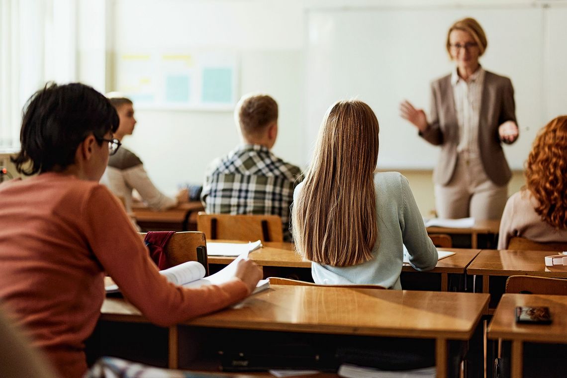 Eine Lehrerin steht vor ihrer Klasse.