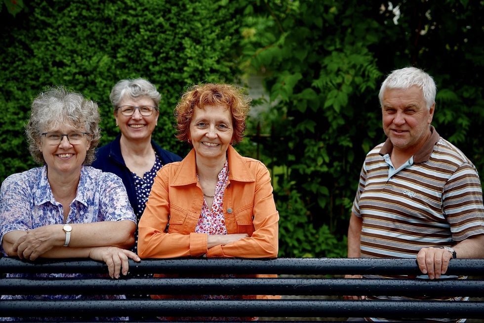 Drei Frauen und ein Mann posieren für ein Foto.