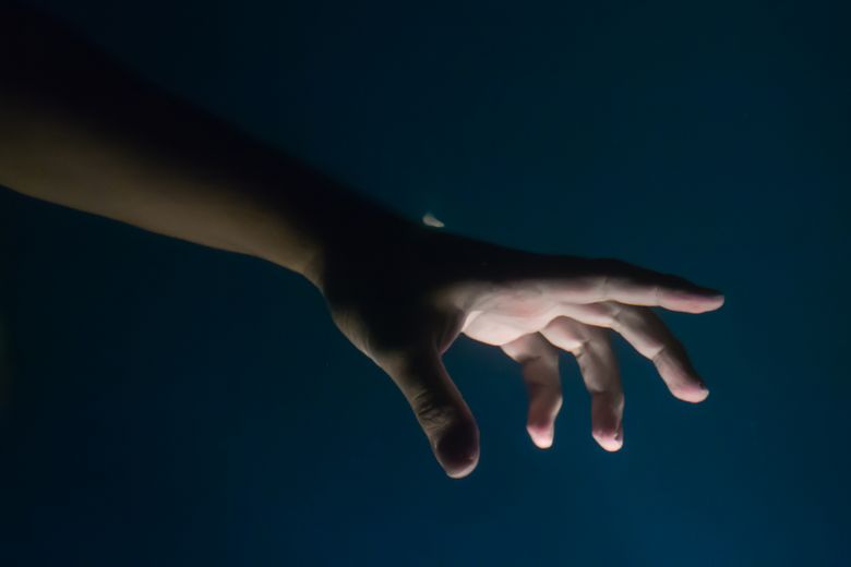 Hand under the water at night Hand greift nach rechts.