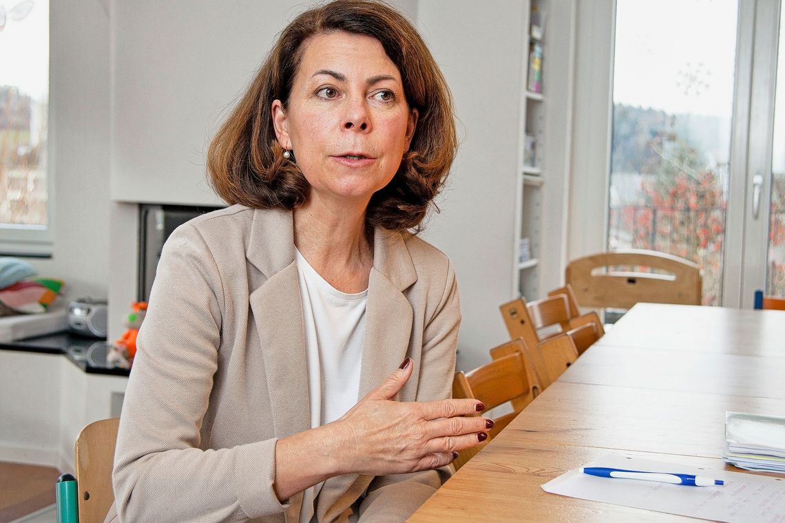 Eine Frau im beigen Blazer im Gespräch.