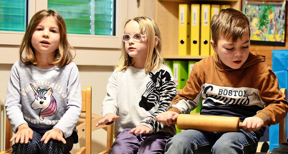 Kinder singen im Kreis.