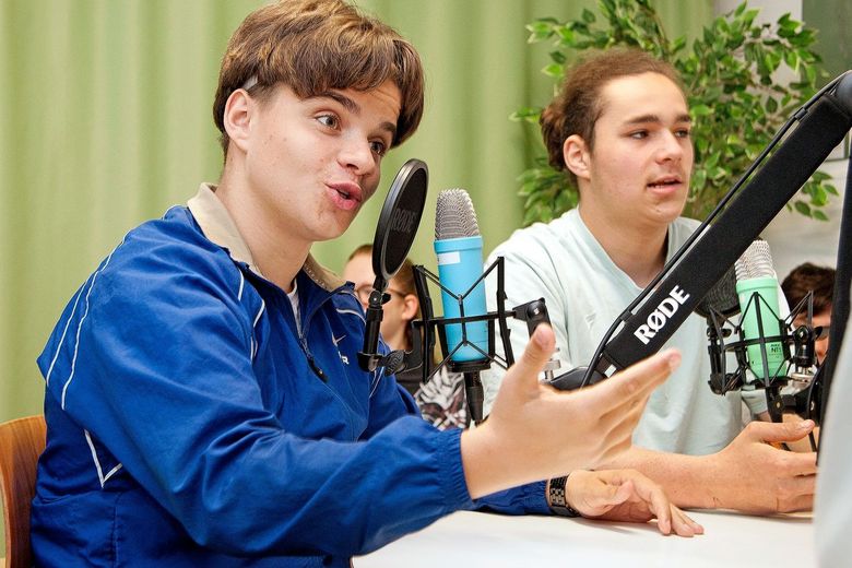 Ein Schüler interviewt für seinen Podcast einen Gesprächspartner.