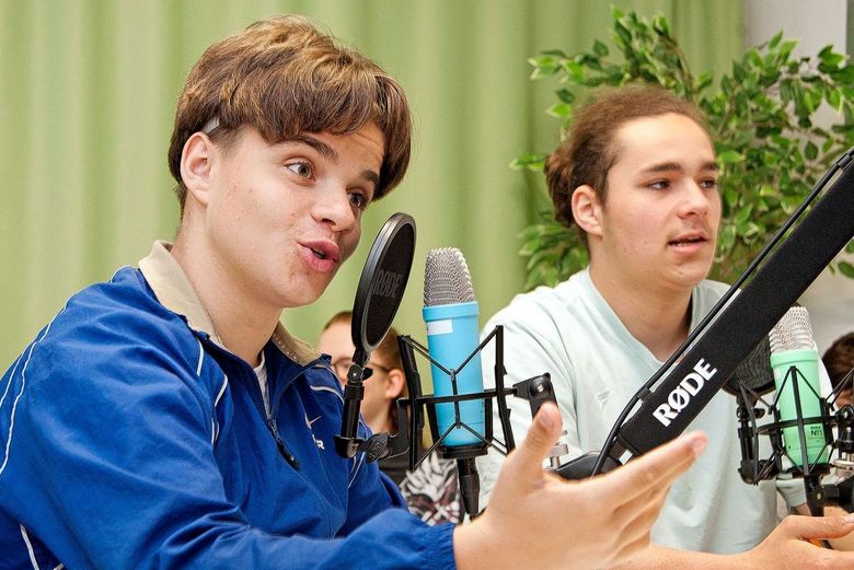 Ein Schüler interviewt für seinen Podcast einen Gesprächspartner.