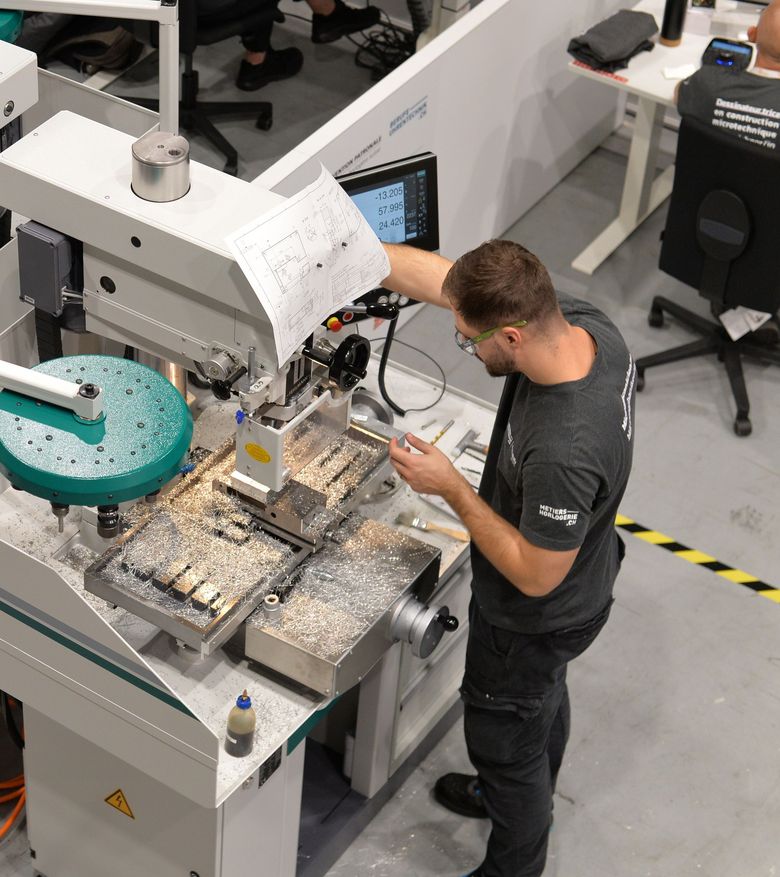 Ein Polymechaniker arbeitet an einer Maschine.