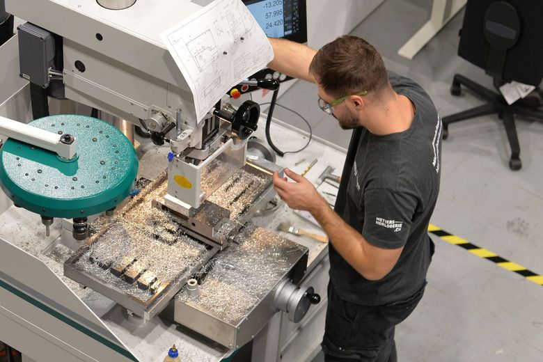 Ein Polymechaniker arbeitet an einer Maschine.