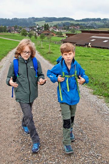 Zwei Jungs wandern auf einem Feldweg.