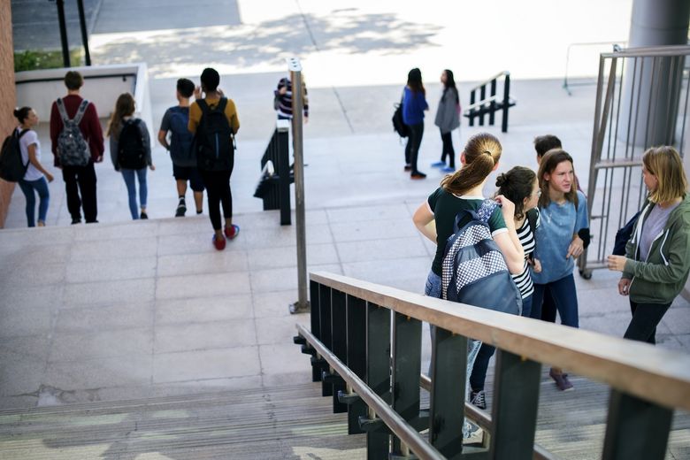 Schülerinnen und Schüler tummlen sich auf der Treppe.
