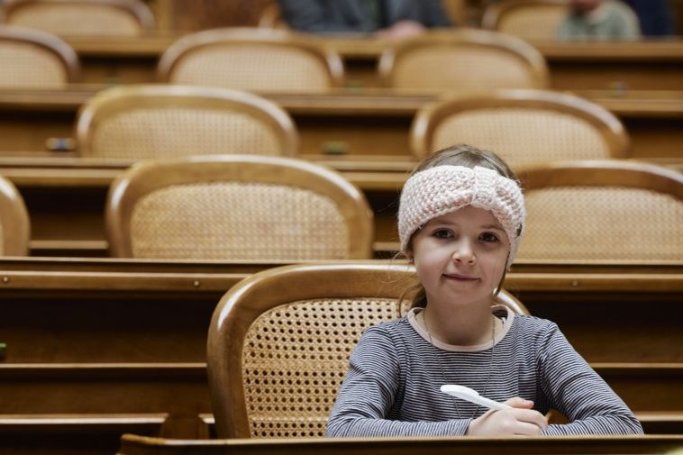 Ein Mädchen sitzt, wo sonst Parlamentsmitglieder hocken. Ein Mädchen sitzt, wo sonst Parlamentsmitglieder hocken.