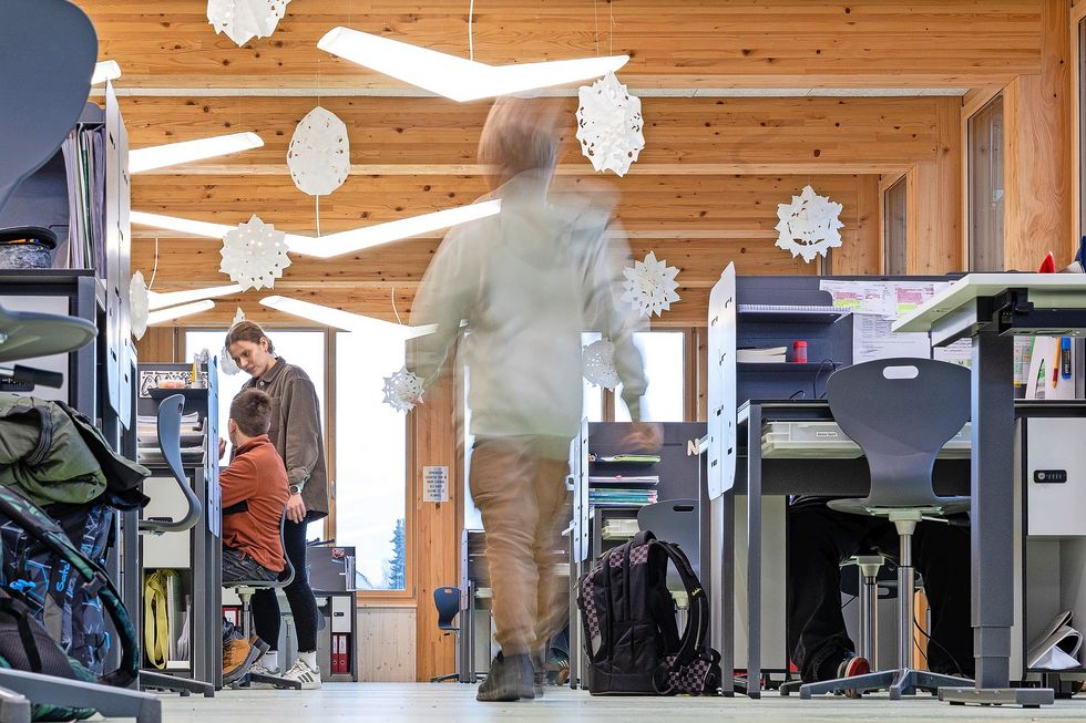 Ein Kind läuft durch ein Lernraum mit Pulten und Stühlen.