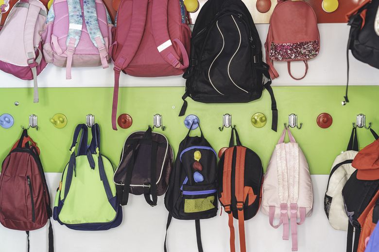 Kinderrucksäcke hängen an einer bunten Garderobe.