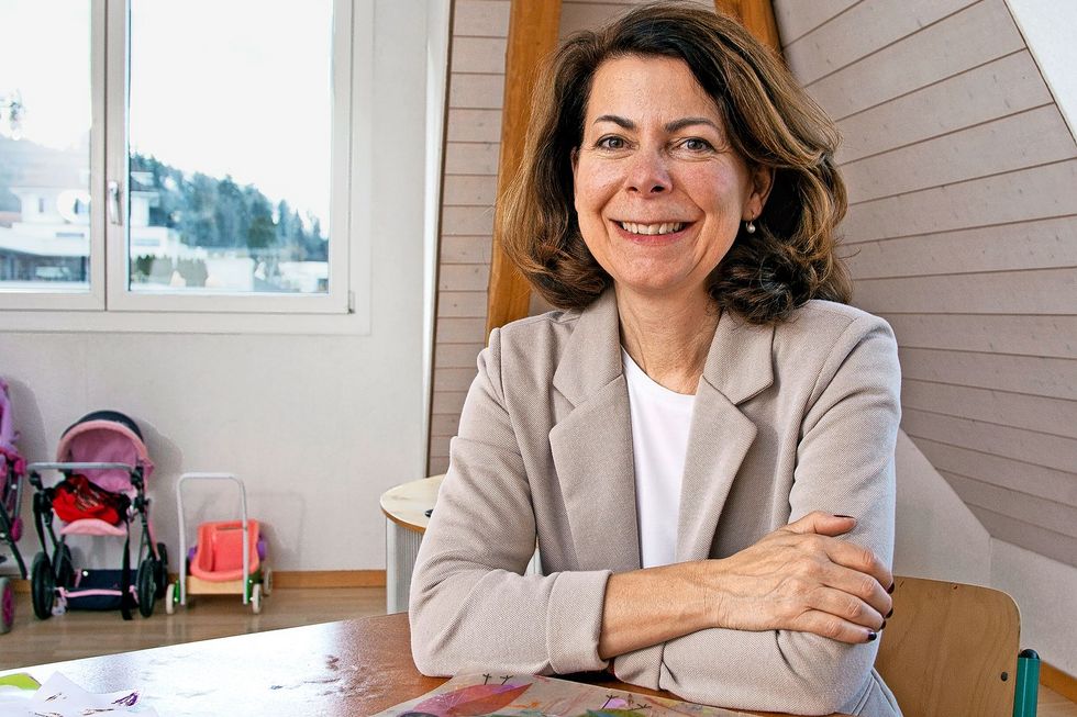 Frau mit beigem Blazer im Gespräch.