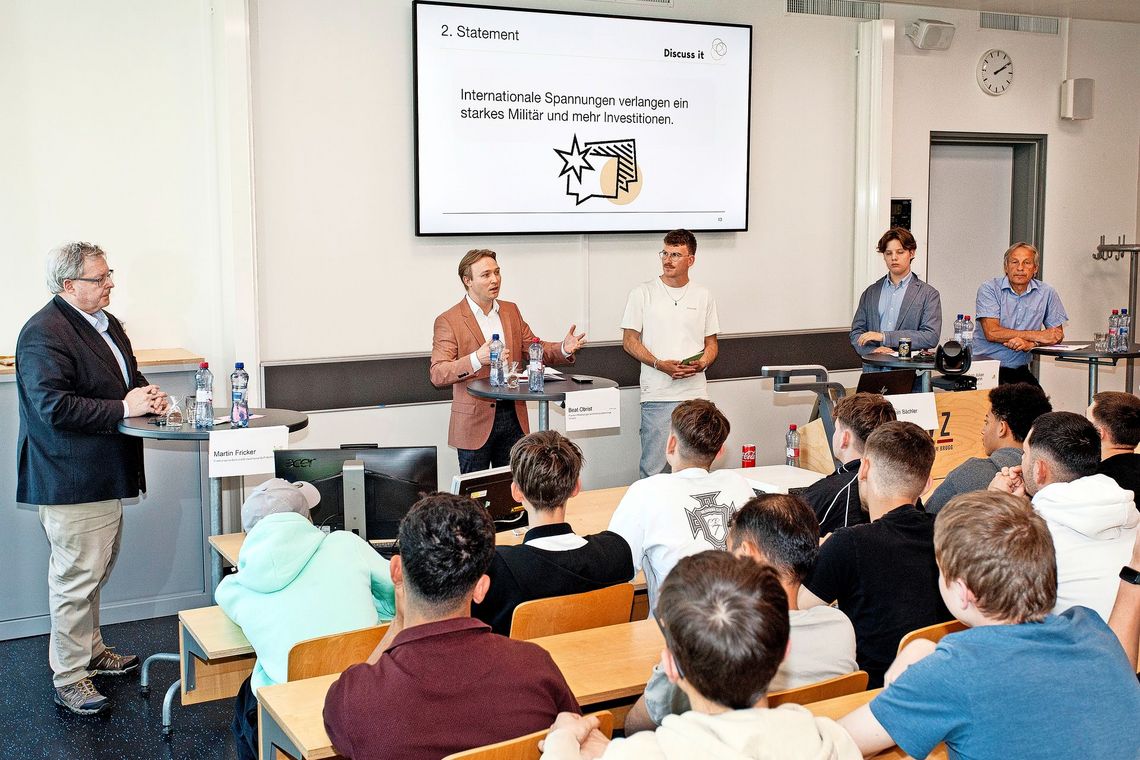 Männer stehen vor einer Gruppe Männer.